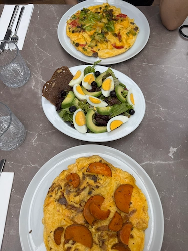 Ekşi Maya Ankara'da sunulan Tatlı Patatesli Omlet, avokado dilimleri, haşlanmış yumurta ve sağlıklı brunch ürünlerinden oluşan bir kahvaltı tabağı.