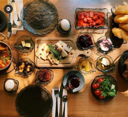 Ankara kahvaltı mekanları Ankara Alaçatı serpme kahvaltı deneyimi sunan Kapı Ankara’da, Ege ezmesi, Alaçatı reçelleri, pişi ve zengin peynir çeşitleri ile donatılmış keyifli kahvaltı masası.