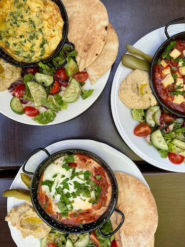 Omlet, şakşukalı yumurta, ekmekli kahvaltı tabakları.